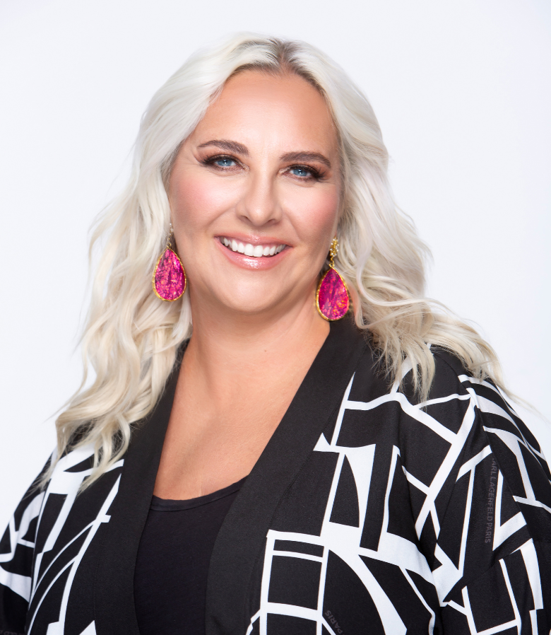 Julie smiling with pink earrings and checkered top